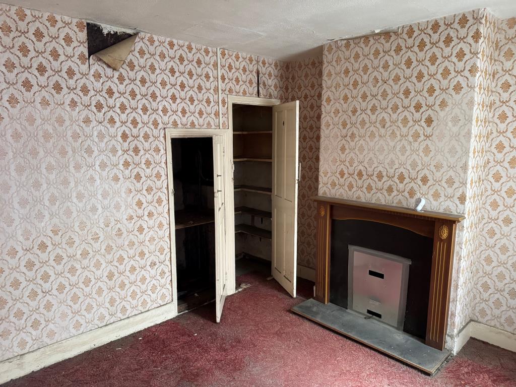 Lot: 133 - FREEHOLD TOWN CENTRE HOUSE FOR IMPROVEMENT - Bedroom with fireplace and built in storage